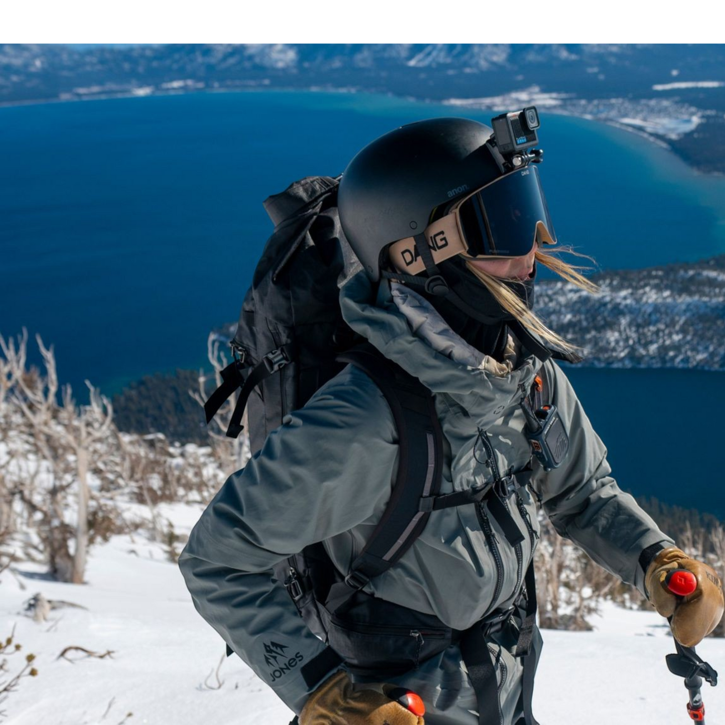 alAsil GoPro HERO action camera mounted on a skier's helmet during a snowy mountain descent overlooking a lake