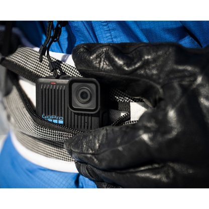alAsil GoPro HERO action camera tucked into a waist pack, worn by a person in a blue jacket and black gloves.