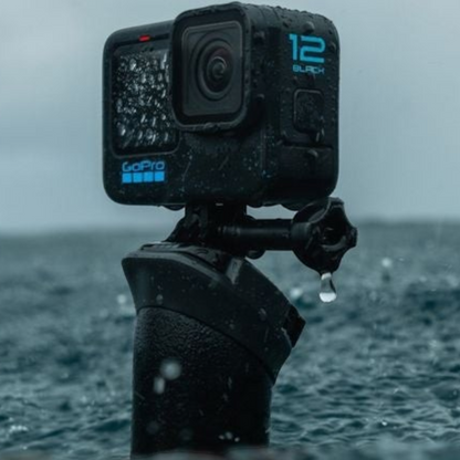 alAsil GoPro HERO12 Black action camera mounted on a grip, wet from rain in a stormy outdoor setting