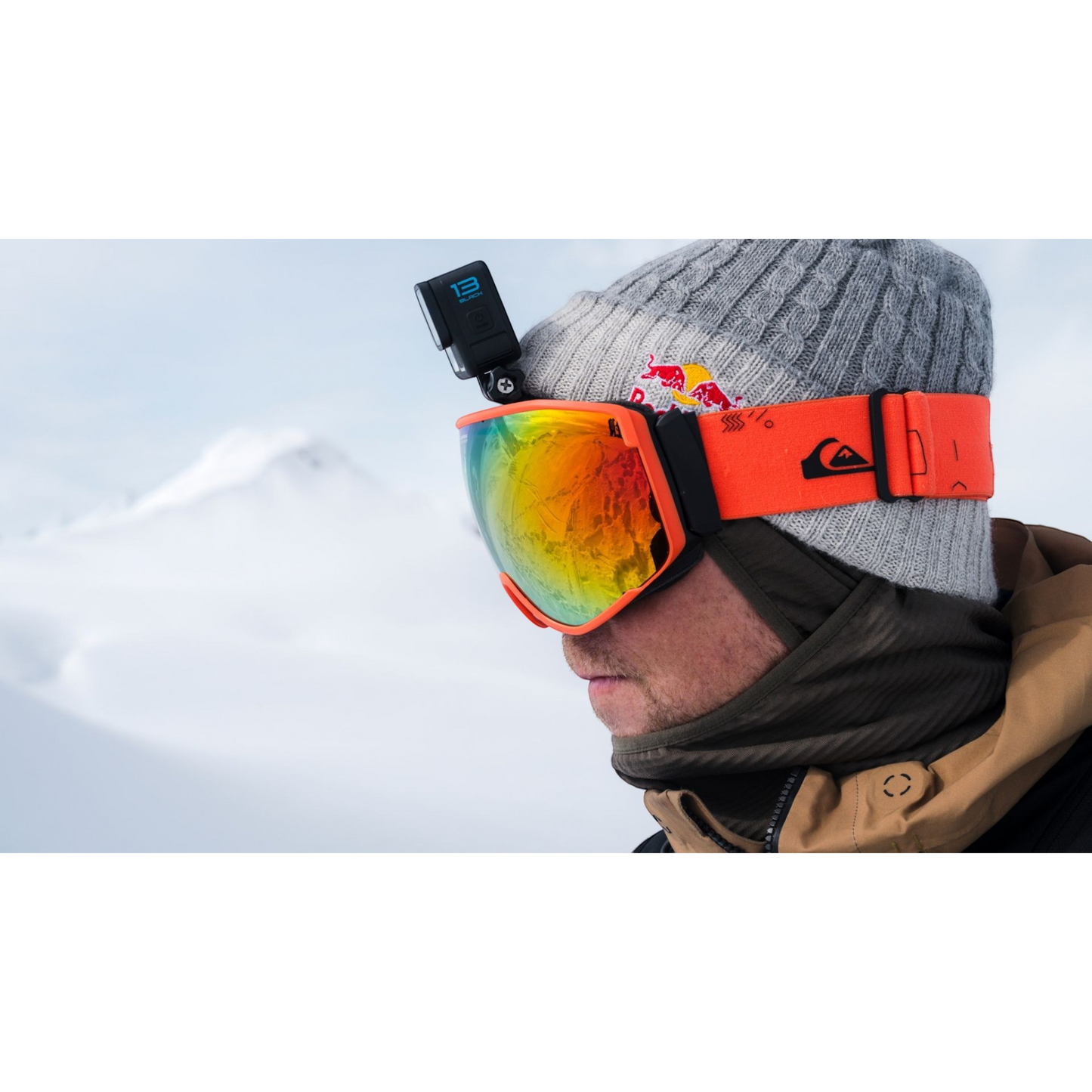 alAsil GoPro HERO13 Black action camera mounted on a skier wearing orange goggles and a grey beanie in snowy mountains