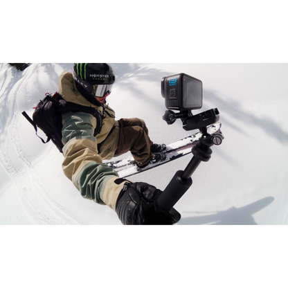alAsil GoPro HERO13 Black action camera mounted on a selfie stick held by a skier on a snowy mountain slope