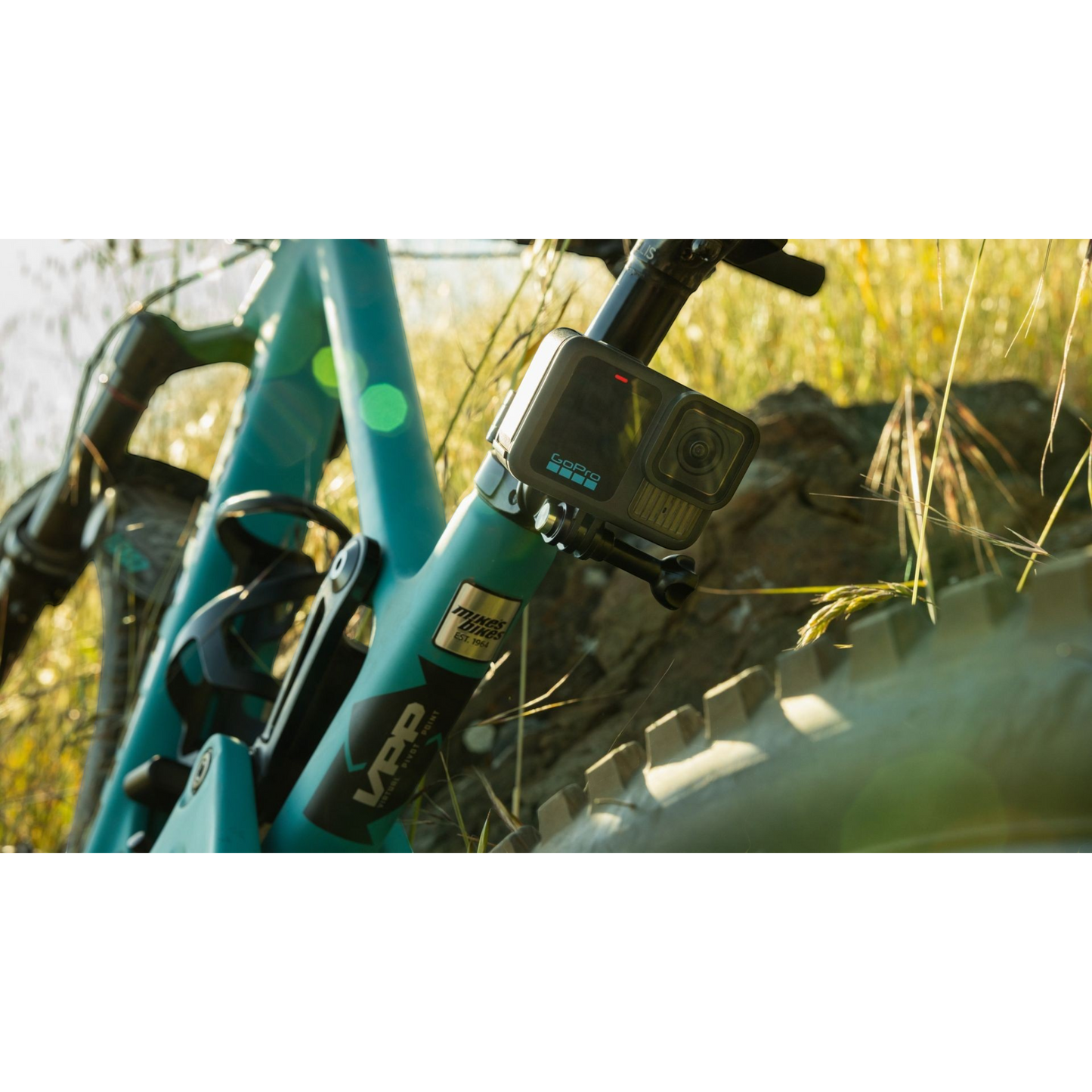 alAsil GoPro HERO13 Black action camera mounted on a teal mountain bike frame outdoors in sunlight