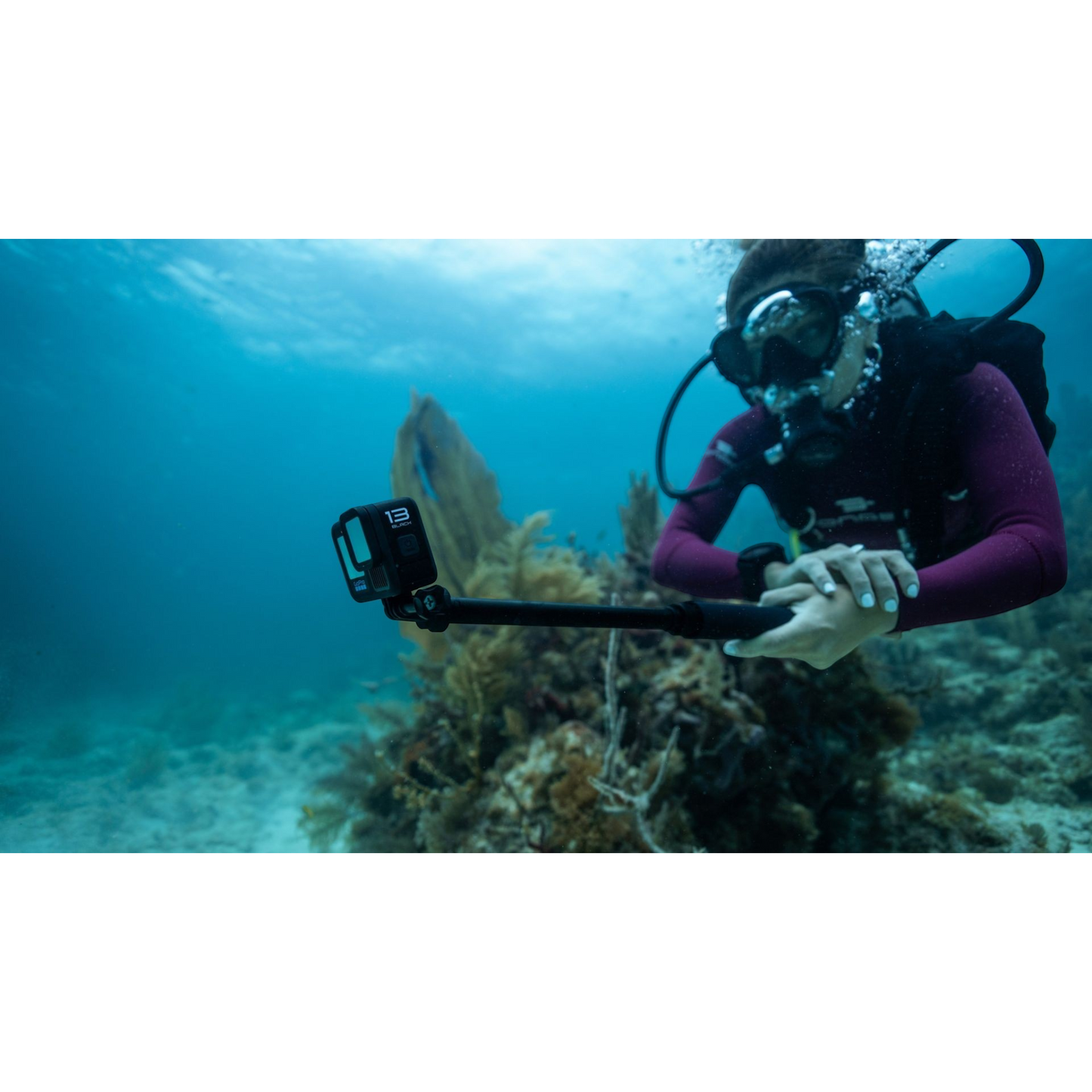 alAsil GoPro HERO13 Black action camera mounted on a selfie stick held by a scuba diver exploring an underwater reef
