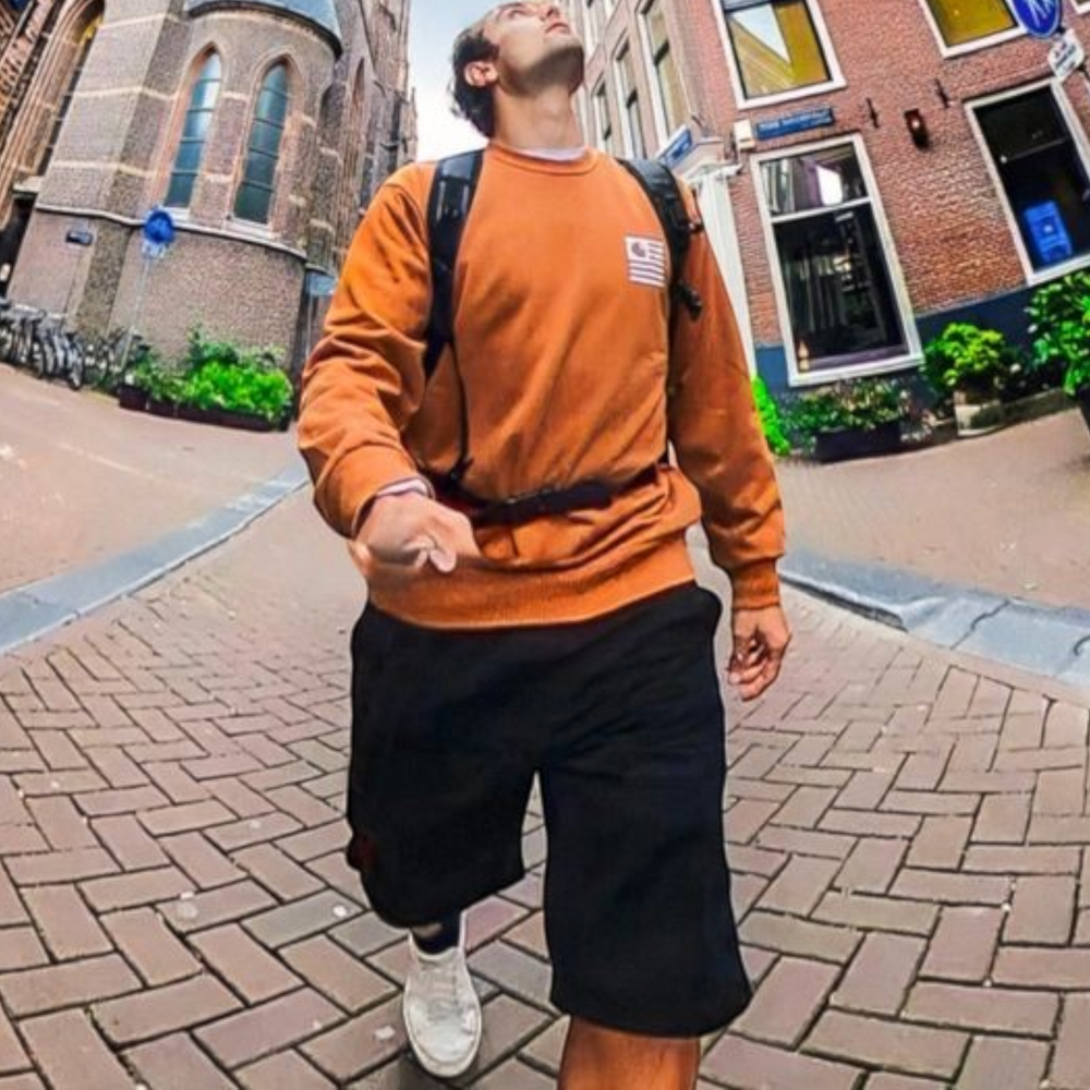 alAsil GoPro MAX 360 camera wide-angle shot of a man walking on a brick street in a city