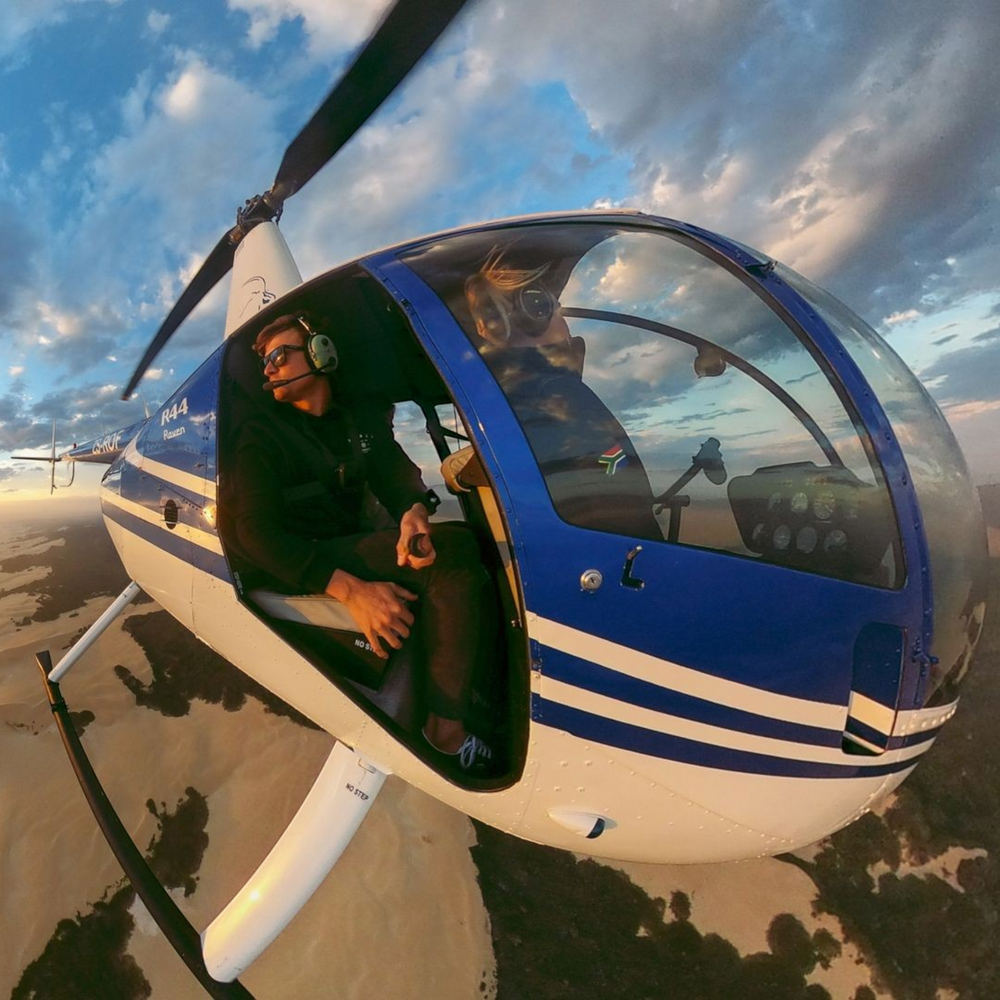 alAsil GoPro MAX 360 camera capturing a pilot in a helicopter cockpit with a wide-angle view of the desert landscape.