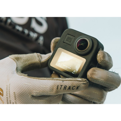 alAsil GoPro MAX 360 camera held in gloved hands showing the front lens and digital display screen