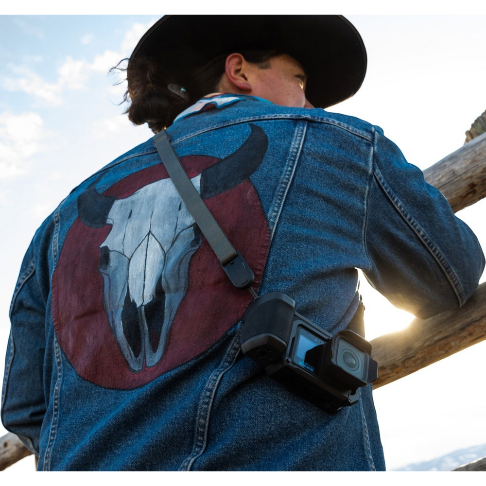 alAsil GoPro MISSION 1 cinema camera hanging on a strap over a person wearing a denim jacket with a bull skull design