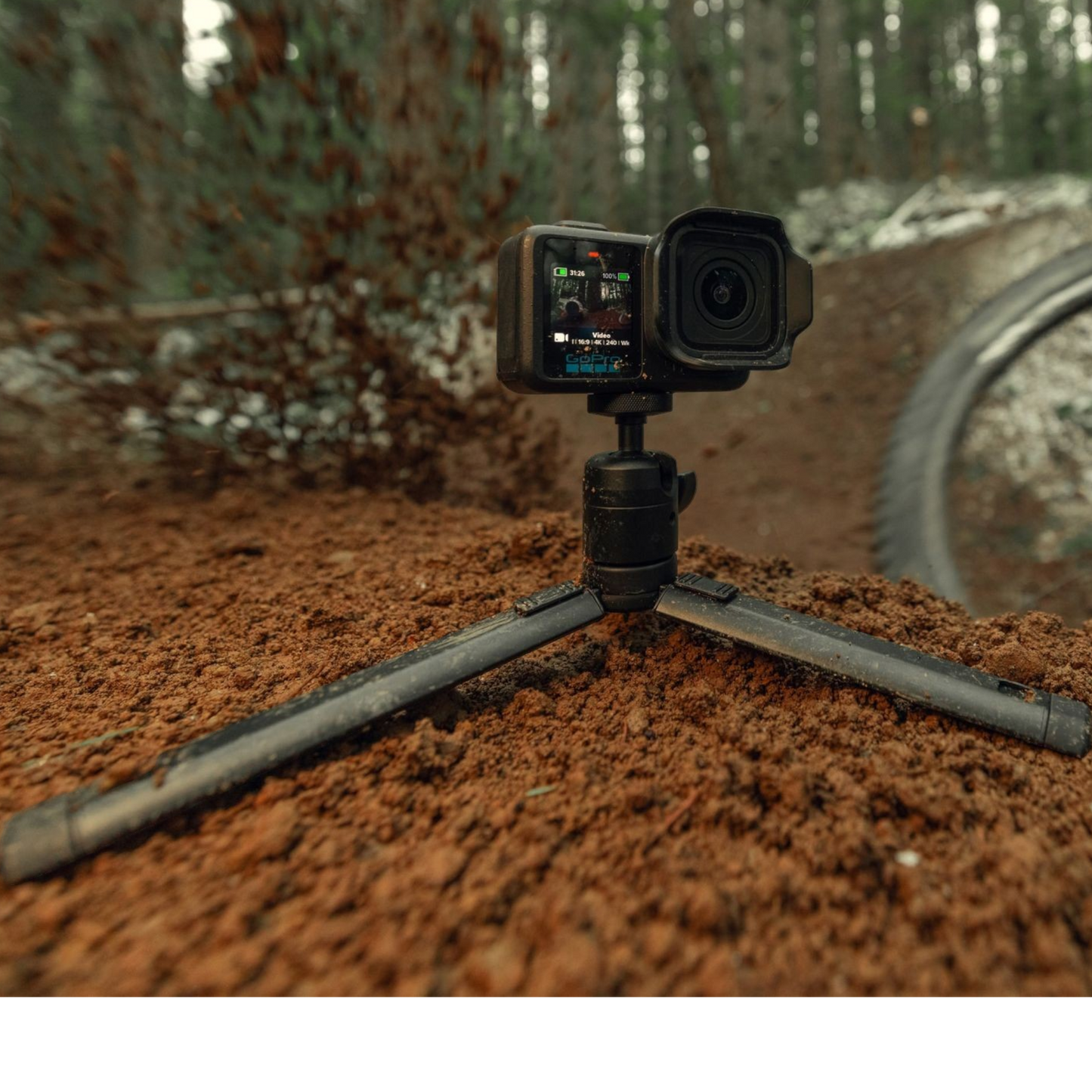 alAsil GoPro MISSION 1 cinema camera mounted on a small tripod on a muddy forest trail for outdoor filming