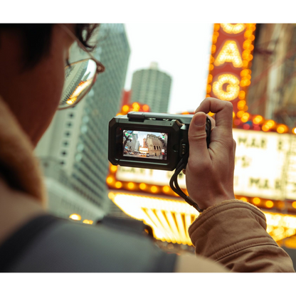 alAsil GoPro MISSION 1 PRO cinema camera held by a creator filming a bright city street scene with neon signs